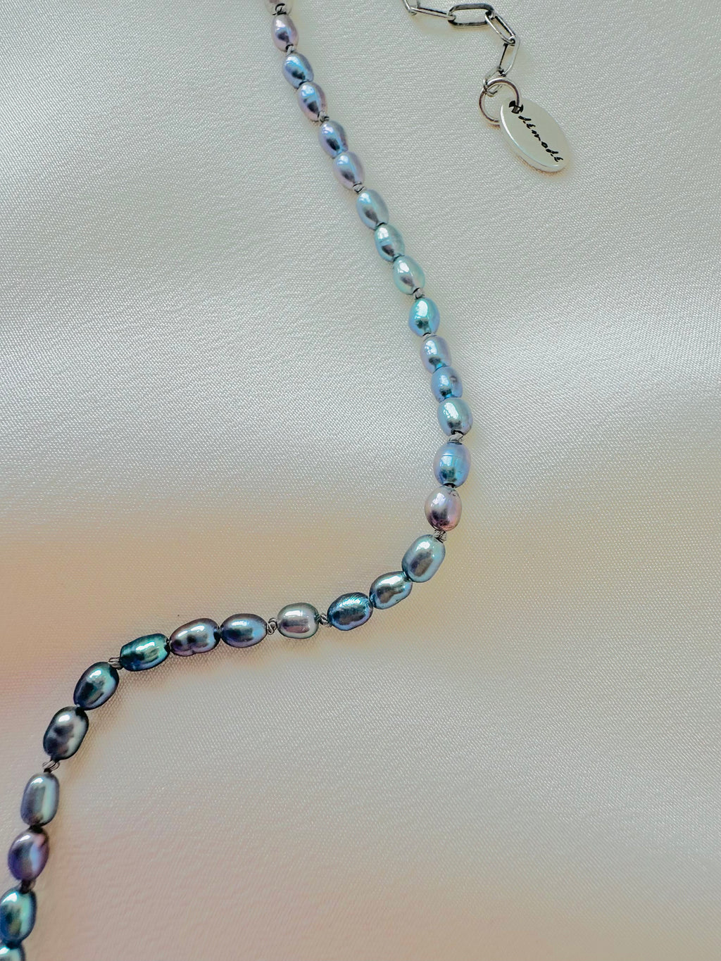 Pearl necklace with a silver clasp on a light fabric background