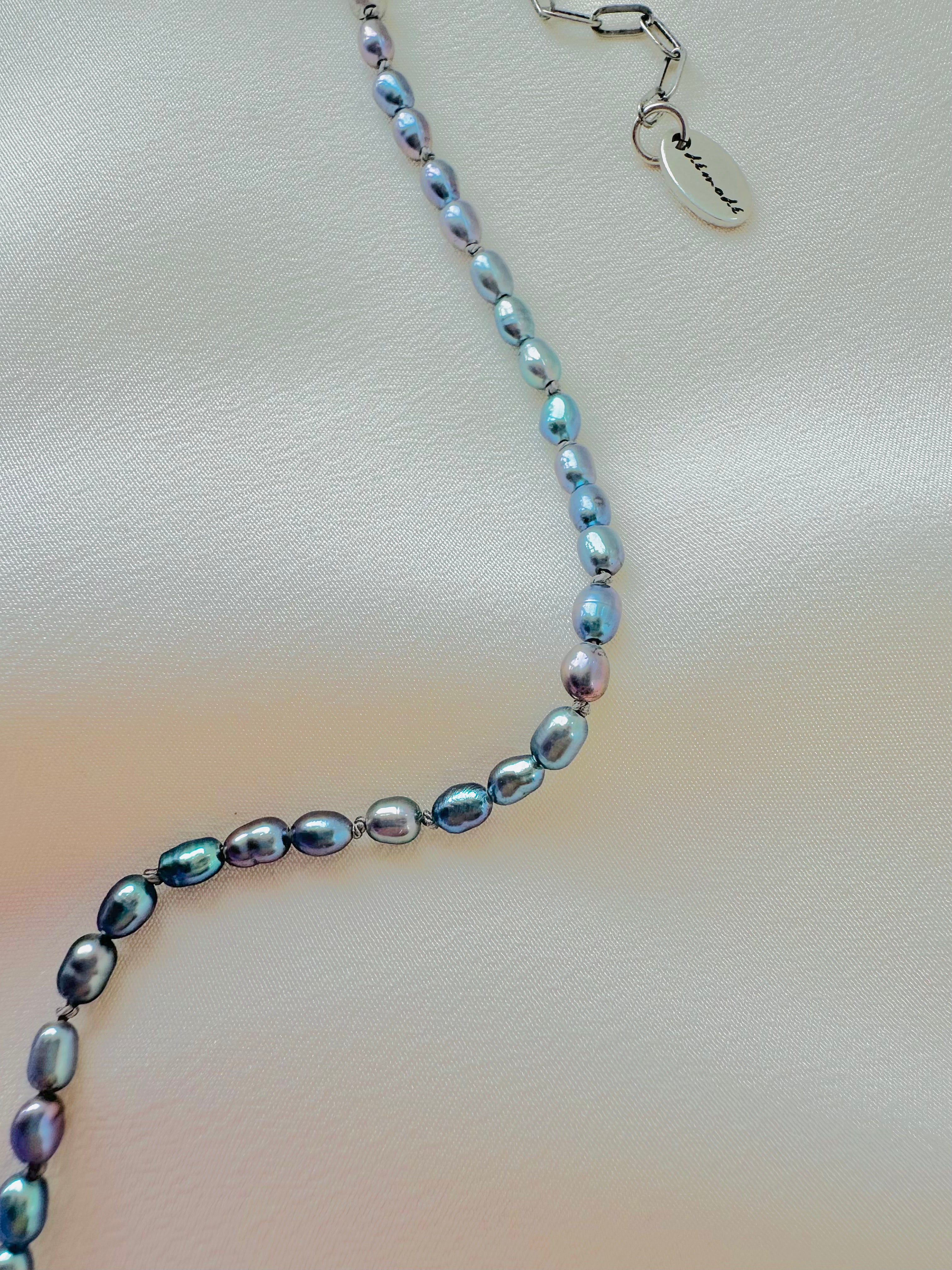 Pearl necklace with a silver clasp on a light fabric background