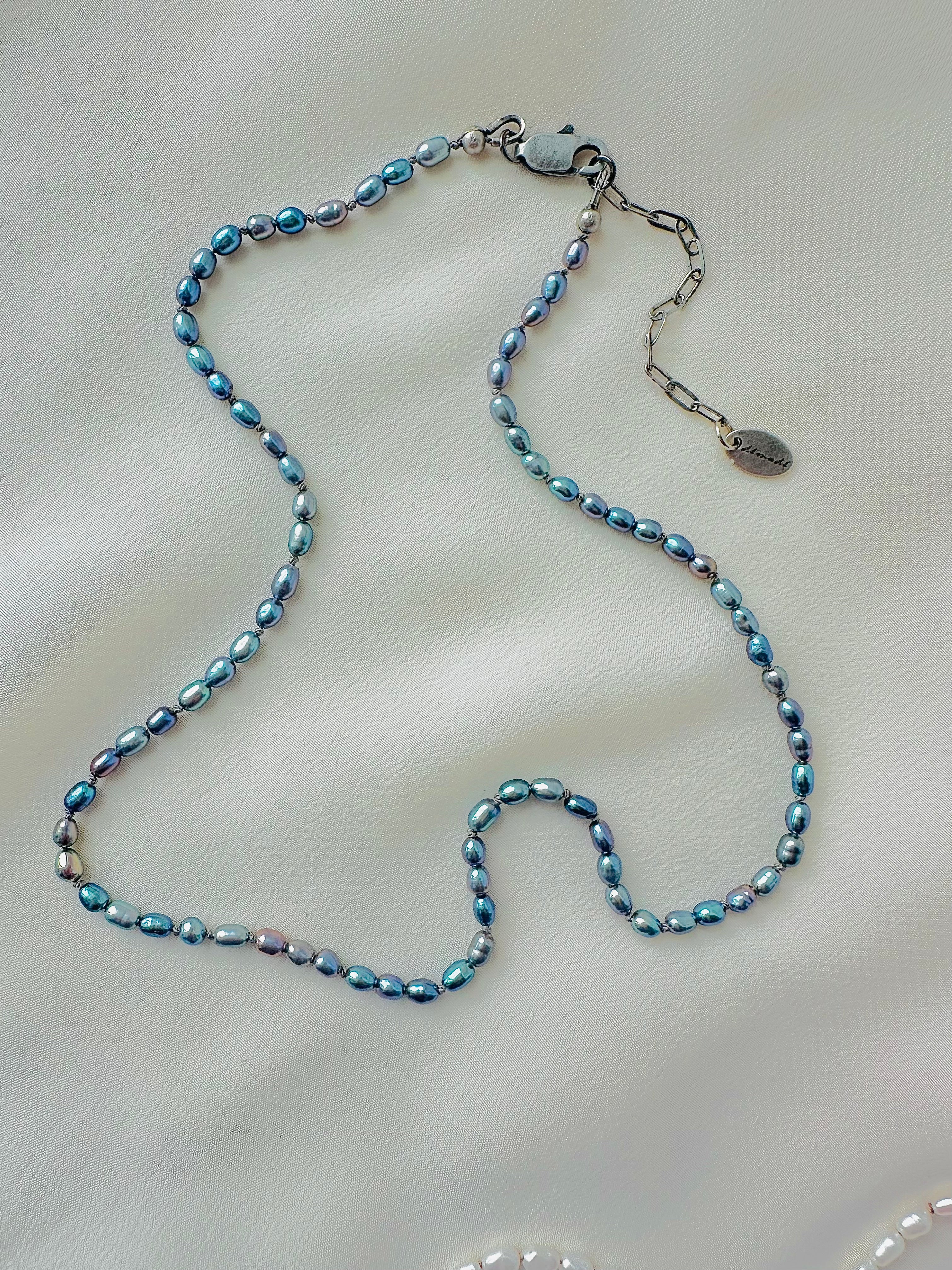 knotted pearl necklace on a light beige surface