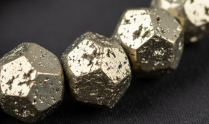 Close-up of metallic beads on a dark fabric background