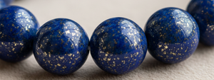 Close-up of a string of blue beads on a textured surface