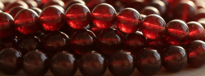 Close-up of a string of red beads on a beige background