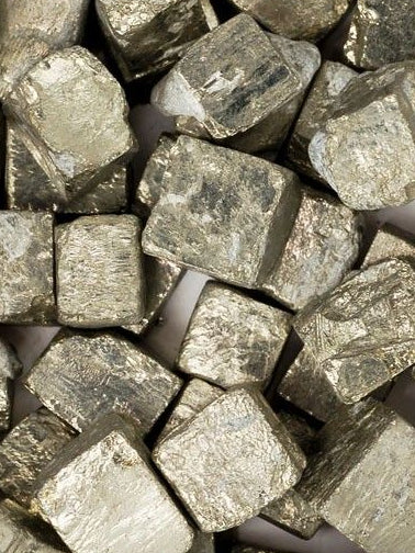 Close-up of pyrite metallic cube-shaped objects on a white background